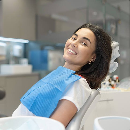 Smiling woman leaning back in the dental chair