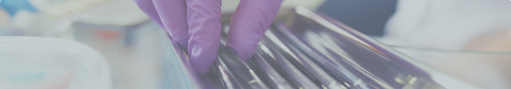 Dentist picking up a dental instrument