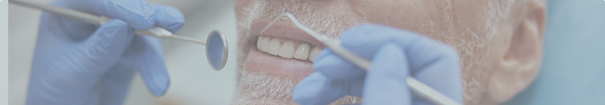 Older man receiving a dental exam thanks to sedation dentistry in Tewksbury