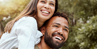 Young man and woman embracing outdoors