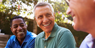 Three men laughing together outdoors