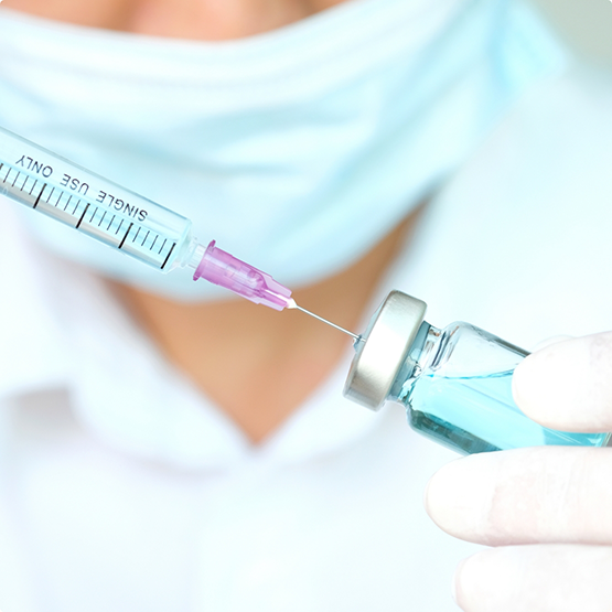Dentist drawing a syringe of clear liquid